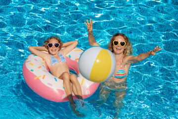 Happy family playing in outdoor pool