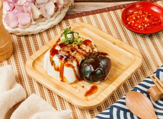 preserved egg tofu in a wooden plate isolated on mat side view on wooden table taiwan food