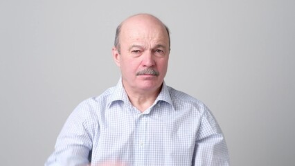 Fototapeta premium Not sure. Mature adult in shirt having a doubt