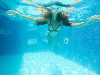 Underwater woman close up portrait in swimming pool.