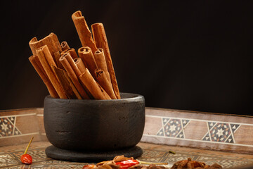 Arabic composition with wooden bowl of spice, cinnamon, peppers, star anise. Shallow depth of field