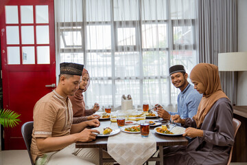 asian muslim friend and family break fasting together in dining room