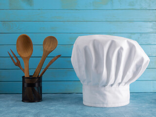 chef's hat on a blue background with kitchen utensils.