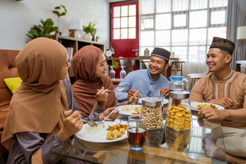 asian muslim friend having iftar dinner together while sitting on the floor in the livingroom