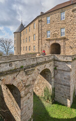 Obraz premium Waldenburg, Baden-Wuerttemberg, Germany, 03-14-2022, woman on bicycle tour on the German route of castles visiting village and castle of Waldenburg