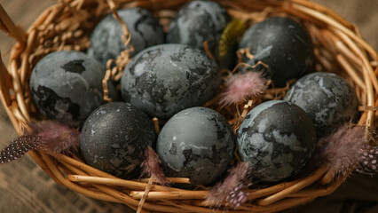 Easter card with a copy of the place for the text. Purple, blue eggs in a basket on a dark newspaper background. Natural dye karkade tea.