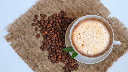 A cup of coffee and grains on a white background.