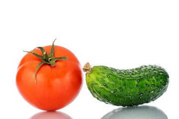 One ripe tomato and cucumber, macro, isolated on white background.