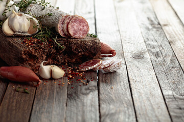 Dry-cured sausage on a old wooden table.