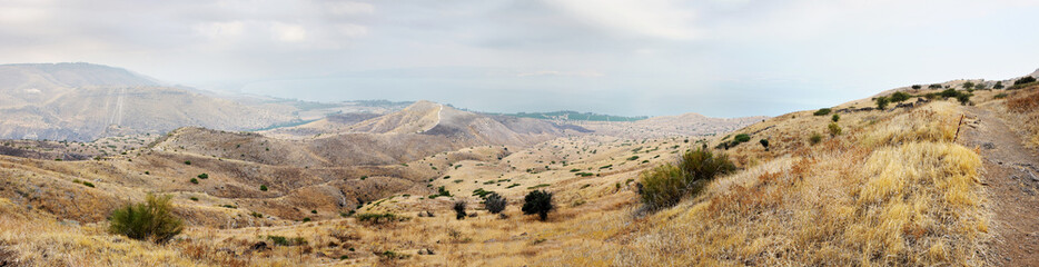 Fototapeta na wymiar Shore of Lake Kinneret, the slopes of the Golan Heights in Israel