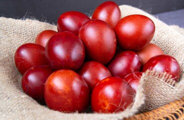 Close-up of red Easter eggs painted with natural dyes with onion husks on burlap. Easter, religious holidays.