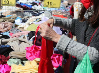 hand of girl who is choosing clothes in the used clothes stall