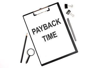 On a white background magnifier, a pen and a sheet of paper with the text PAYBACK TIME . Business concept