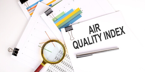 AQI Abbreviation of air quality index text on white paper on the light background with charts paper