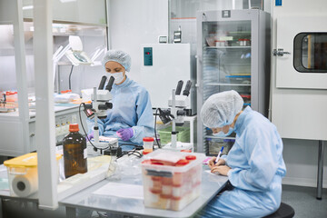 Women work in the lab. Conducts experiments on vaccines.