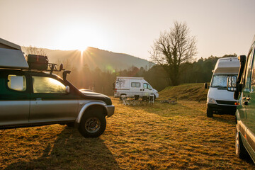 Group of 4x4 camper at sunrise between mountains