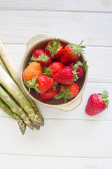 Fresh strawberries and Green Asparagus on white