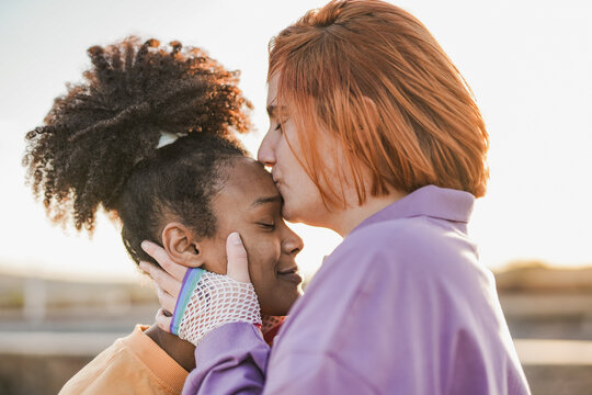 Lesbian multiracial couple having tender moment at sunset