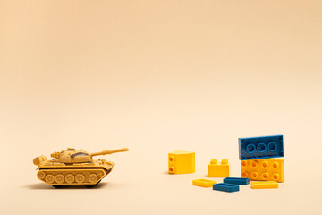 Tank, dominos and toy blocks on sand color background. Minimal Ukraina concept.
