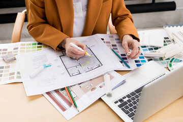 Woman architect working on interior renovation in workplace. Designer choosing color samples according to the visualization and blueprints of the project. Architecture and interior design concept. - obrazy, fototapety, plakaty