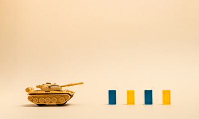 Tank and toy dominos on sand color background. Minimal Ukraina concept.