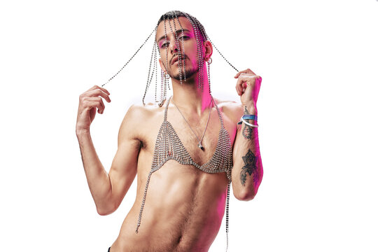 Young model with tattoos, wearing silver bra and makeup. Posing with a white background, magenta light and silver accessories. Showing her feelings.
