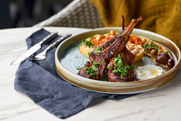Raw rack of lamb fried with aromatic olive oil, herbs and spices