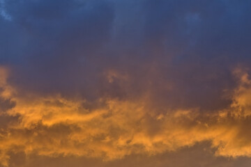 Fototapeta premium Colorful cloudy evenig sky in blue, orange and grey