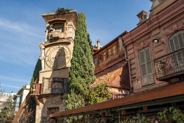 The Leaning Clock Tower at the Tbilisi Puppet Theater on pedestrian street in the old town of Tbilisi, Georgia - obrazy, fototapety, plakaty
