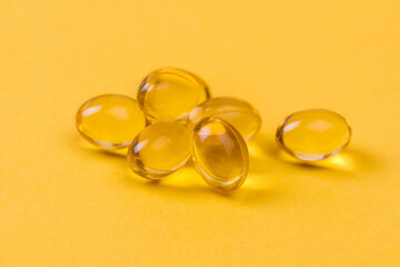 Close up of  oil filled capsules suitable for: fish oil, omega 3, omega 6, omega 9,  vitamin A, vitamin D, vitamin D3, vitamin E - Image