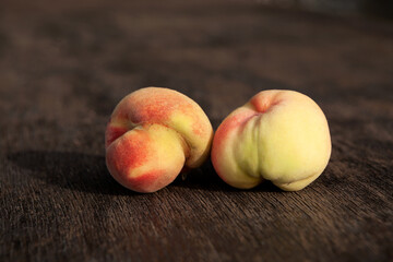 Ugly crooked peaches on dark wooden background. Concept - reducing food waste. Organic garbage