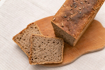 sliced rye bread on a wooden board on a white background