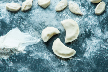 Raw dumplings or varenik. traditional  Ukrainian food, close up. dumplings with potatoes on a dark background.
