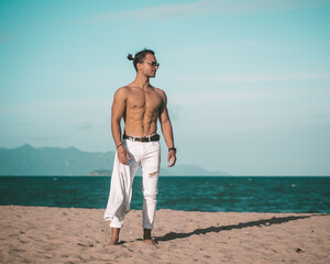 Shirtless man on the beach with the ocean background