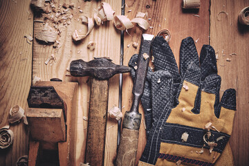 Carpenters tool kit, hammer, chisel and plane with gloves wooden background.