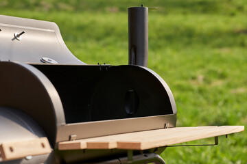 New smoker barbecue grill. Equipment for cooking and smoking. Device in nature.