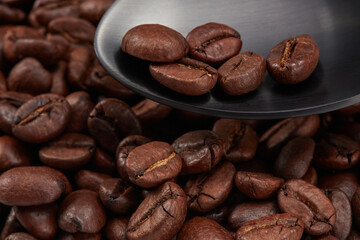 Coffee beans in a dark gray spoon. Shallow depth of field