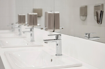interior shot of a modern bathroom in the foreground the washbasin with a steel tap
