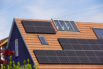 Ökologisches Holzhaus mit Photovoltaik Modulen und Solarthermie Panelen auf dem Ziegeldach