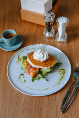 Feta cheese in the form of a star on a pancake lying on pieces of red fish. Breakfast at a fast food restaurant