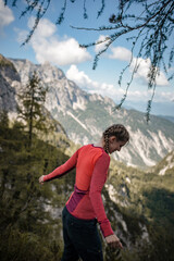 Naklejka premium Young woman is having fun on viewpoint in Julian Alps during her autumn hike in Slovenia.