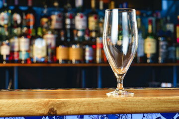Empty beer glass on a wooden bar counter