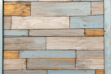 Naklejka premium A patchwork of recycled wooden squares making up a verticle wall. 