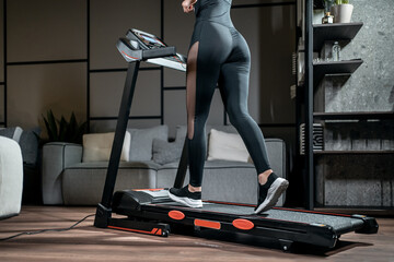 beautiful female athlete running on treadmill at home workout - obrazy, fototapety, plakaty