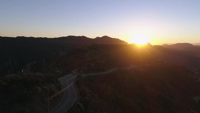 Aerial Forward Shot Of Car Parked On Mountain Road During Sunset - Malibu, California