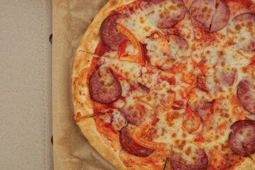 food and pieces of fresh colored pizza carbonara in a brown paper carton box