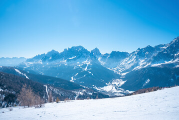 Fototapeta na wymiar Panoramic view of majestic kronplatz mountain range against blue sky. Scenic snow covered landscape during winter. Idyllic view of alpine region.