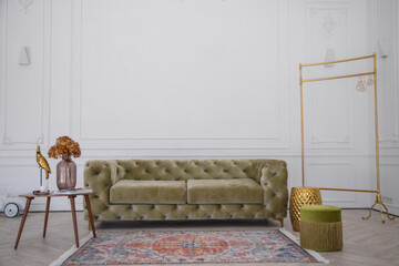 Green velour sofa in white room with classic interior