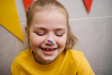 cheerful girl with a nose stained in paint