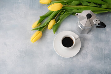 Still life with coffee and bouquet of yellow tulips.